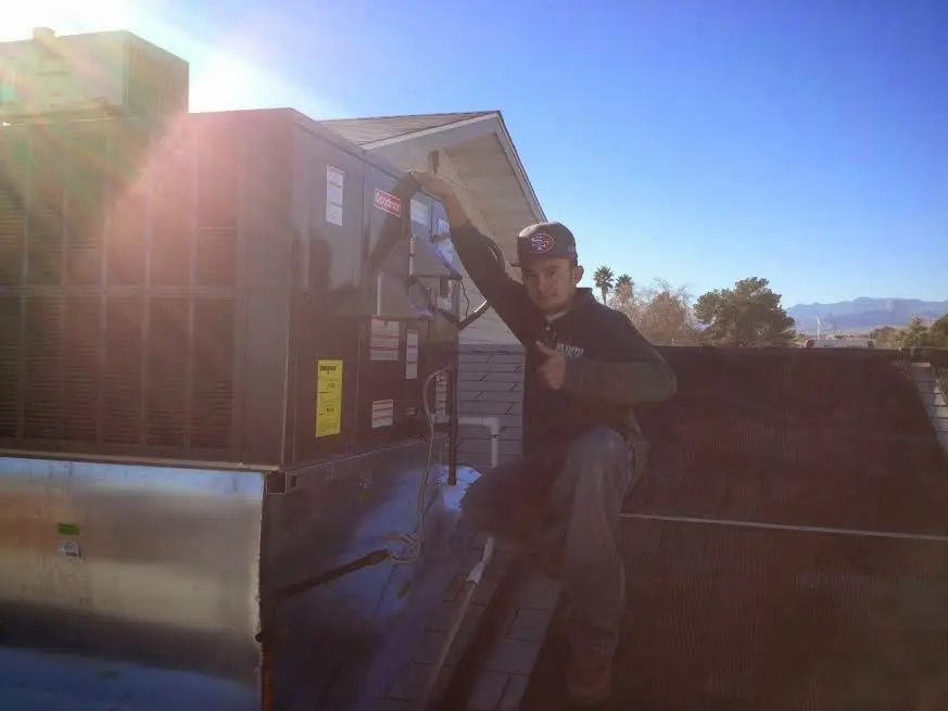 HVAC technician performing Boiler Repair on a rooftop unit in Winters